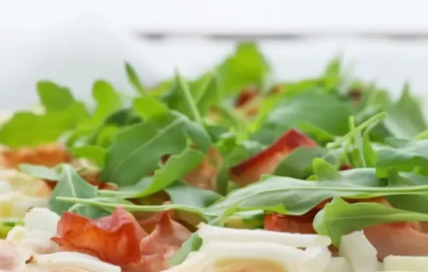 Knuspriger Flammkuchen mit würziger Schmandsoße und frischem Rucola