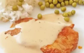 Köstliches Naturschnitzel mit cremiger Pfefferrahmsauce, dazu Reis und Erbsen