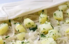 Leckerer veganer Krautstrudel mit knuspriger Teighülle und würziger Füllung, begleitet von Petersilkartoffeln.