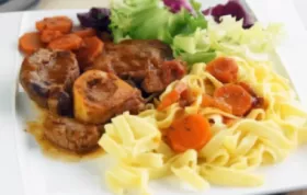 Zartes Kalbsfleisch in einer aromatischen Tomatensauce mit Gemüse und Kräutern.